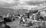 Durch Mostar führte die erste von Österreich-Ungarn errichtete schmalspurige Narentabahn (760 mm Spurweite) nach Sarajevo. Das wesentlich bekanntere Wahrzeichen war aber Stari most, die Brücke über die Neretva. Während des Bosnienkrieges 1992/1993 wurde die Brücke aus dem 16. Jahrhundert durch gezielten Beschuss durch kroatische Streitkräfte am 9. November 1993 zerstört. Im Mai 2013 verurteilte der Internationalen Strafgerichtshofs für das ehemalige Jugoslawien (ICTY) sechs Verantwortliche wegen schwerer Kriegsverbrechen und Verbrechen gegen die Menschlichkeit, aber auch wegen Zerstörung der Brücke erstinstanzlich zu langjährigen Haftstrafen. 1995 wurde der Wiederaufbau der Brücke beschlossen. Dabei wurden, soweit noch vorhanden und nutzbar, die alten Steine wiederverwendet und fehlende aus demselben Steinbruch wie 1566 ersetzt. Die offizielle Wiedereröffnung der Brücke fand unter Anwesenheit von Vertretern aus 60 Staaten am 23. Juli 2004 statt. (08.1969) <i>Foto: Münzenmayer</i>