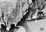 Die Höllentalbahn von Freiburg (Breisgau) in den Schwarzwald stellte mit Steigungen von bis zu 57 Promille seit ihrer Inbetriebnahme 1887 extreme Herausforderungen an den Zugbetrieb. 1934 entschloss sich die Reichsbahn zur Elektrifizierung, allerdings nicht mit der üblichen Spannung von 15 kV, 16 2/3 Hz, sondern mit 20 kV und 50 Hz. Hierzu wurden vier Versuchsloks geliefert, E 244 31 am 6. Januar 1936 von Krupp, es folgten E 244 11 (BBC), E 244 21 (Siemens) und E 244 01 von AEG, wobei sich E 244 21 als die einfachste und anspruchloseste Maschine herausstellte. Die neue E 244 21 vom Bw Freiburg (Breisgau) Pbf ist hier am Hirschsprung, der klammartig engsten Stelle des Höllentals unterwegs. Die Hirschsprung-Enge war vor dem Ausbau der Straße (heute B 31) an der Basis nur 9 Meter breit. Die Hirschsprung-Sage besagt (der Hirsch ist übrigens etwas verdeckt links oben hinter dem Baum zu sehen), dass das bei einer Jagd von Todesangst getriebene Tier mit einem gewaltigen Satz über die Schlucht sprang und dadurch seinen Verfolgern entkam.  (1937) <i>Foto: RVM</i>
