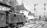 E 32 34 wartet im Bahnhof Schopfheim auf die Ausfahrt nach Zell (Wiesenthal). Rechts rangiert eine E 44¹¹. Der Bahnhof Schopfheim lag an der Wiesentalbahn und war Ausgangspunkt der Wehratalbahn nach Bad Säckingen. Mit der Stilllegung der Wehratalbahn ab 23. Mai 1971 verlor der Bahnhof erheblich an Bedeutung und zugleich seinen Status als Anschlussbahnhof. Die damals in Schopfheim stationierte Kleinlok büßte zahlreiche Rangieraufgaben ein und wurde zurückgezogen.  (30.10.1965) <i>Foto: Karl Wyrsch, Slg. D. Ammann</i>